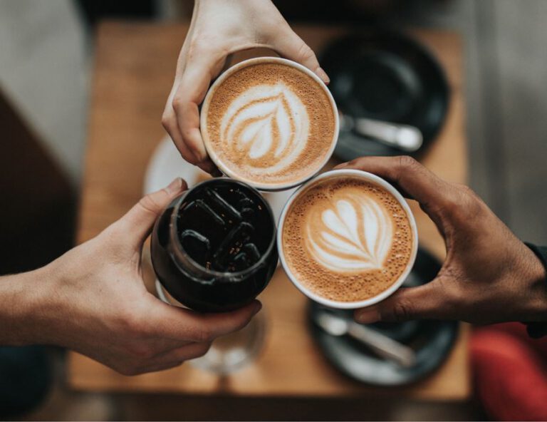 Drei Hände halten Kaffeetassen